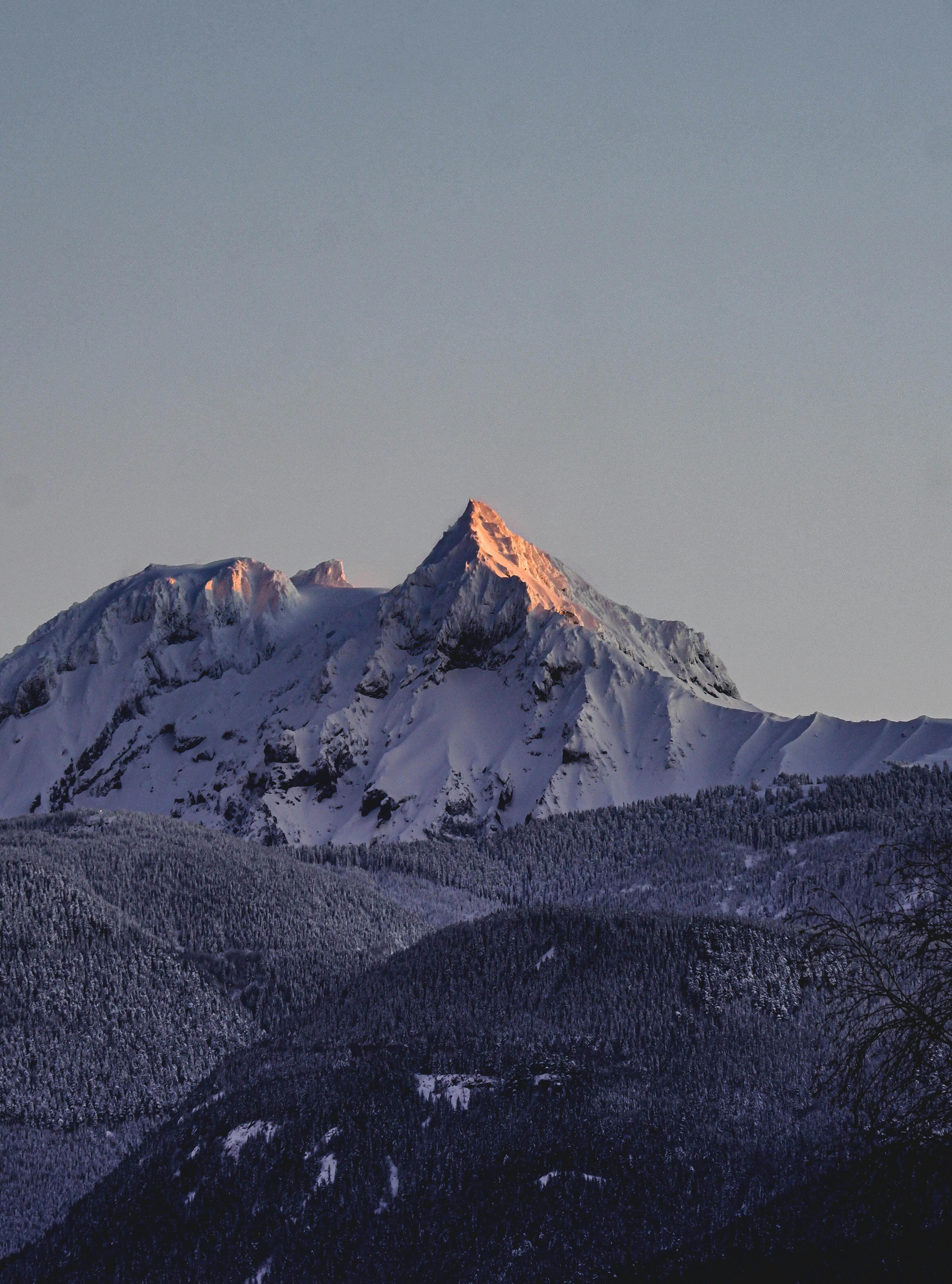 Snow-lit alpine summit at dusk